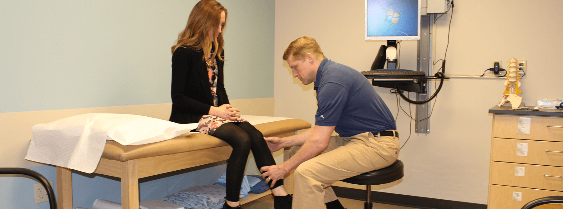 doctor chris bales providing a knee examination to patient