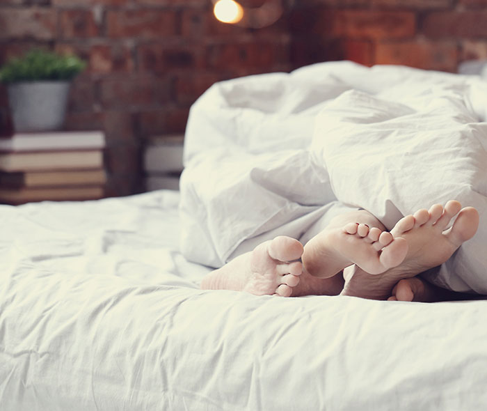 Couple's feet under blankets