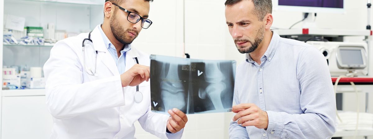 Doctor and Patient Reviewing X‑ray Image During Orthopedic Consultation